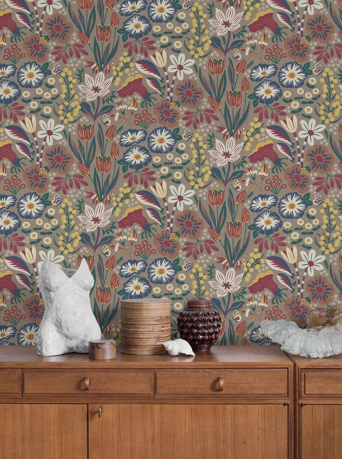 Set on an almond-colored base, our Trädgården wallpaper features dark green leaves, yellow mimosas, burgundy and white tulips interspersed with charming butterflies.