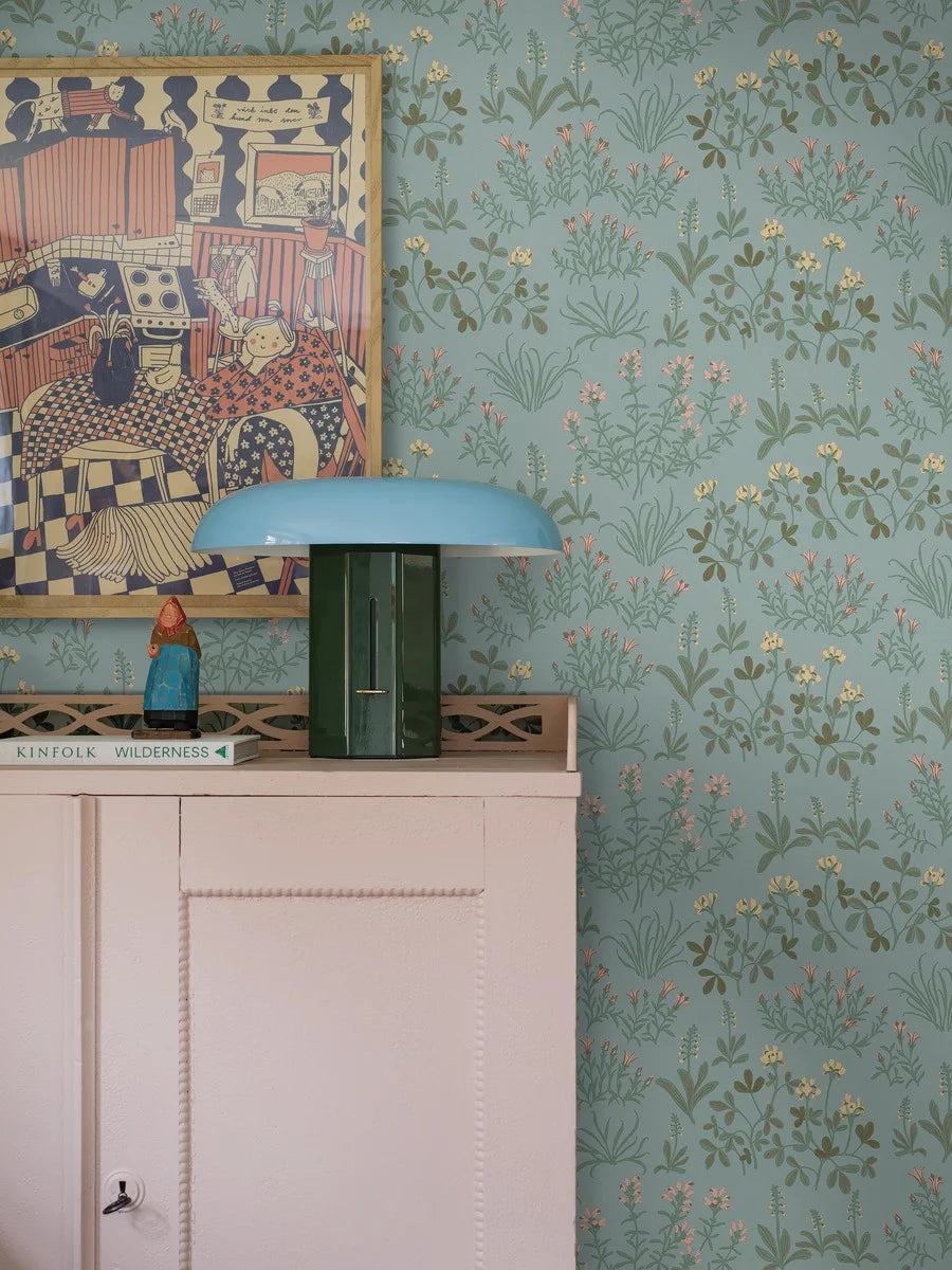 Soft yet striking, our Noras Äng wallpaper combines a serene blue base with warm hues of honey yellow and pretty pink.