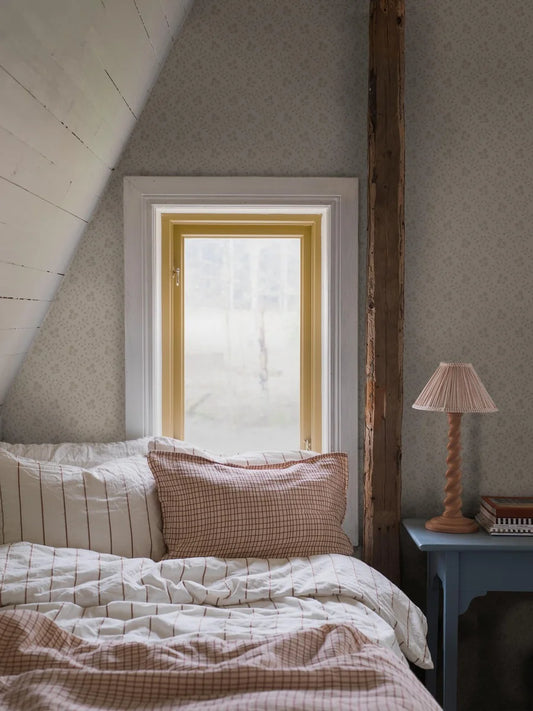 Subtle and sophisticated, our Idun wallpaper features a warm beige background with tone-on-tone beige flowers encased by a decorated yet dainty winding trellis. 