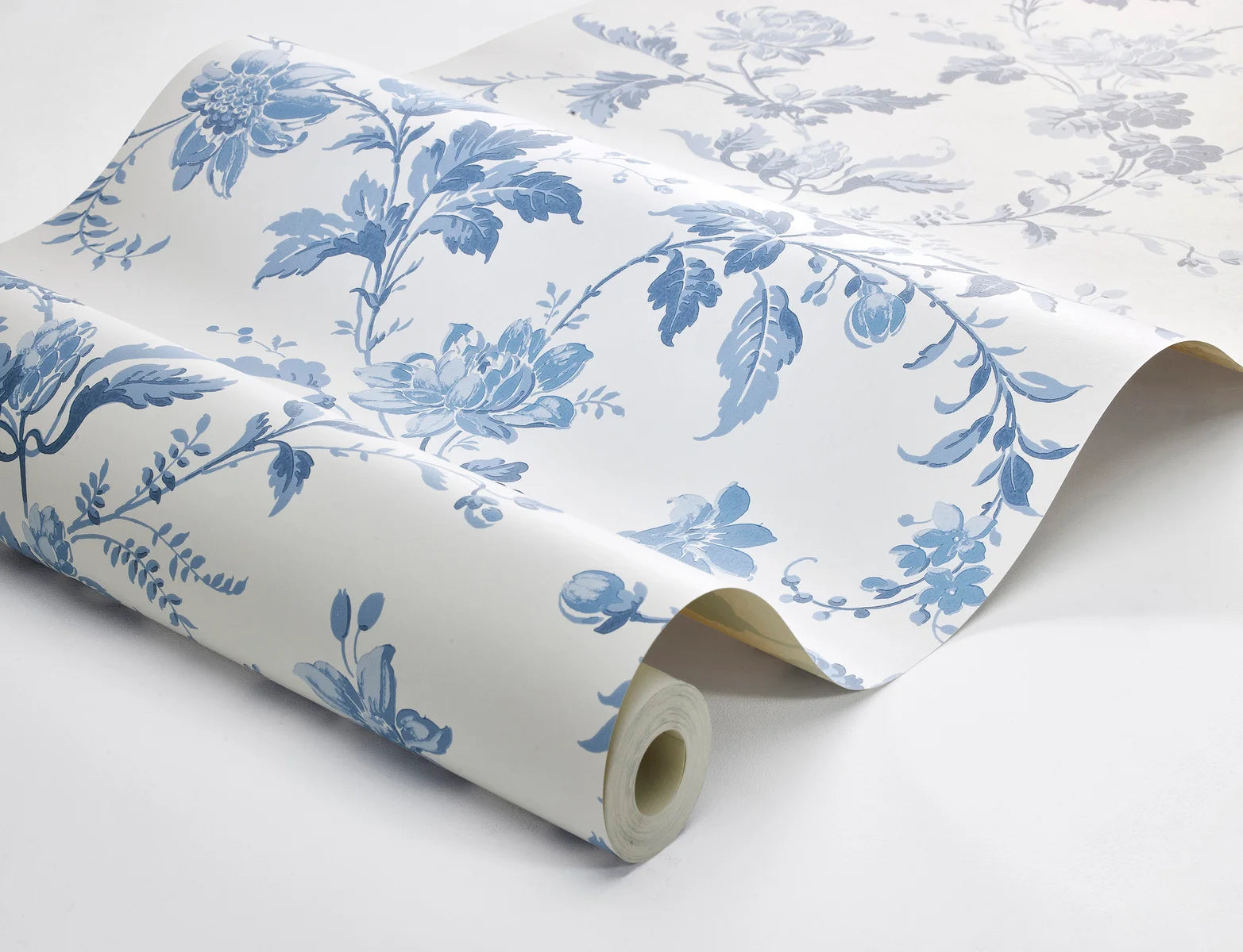 Reviving the charm of the late 1800s, our Blomslinga wallpaper in a traditional surface print, features delightful blue flowers and leaves on a fresh white base.