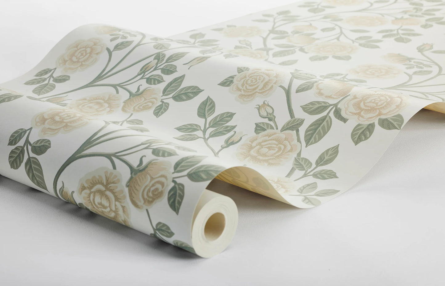 This Elsa wallpaper has a romantic pattern of hand-painted roses colored in cream and honey tones, accented by warm green leaves on an off-white background.