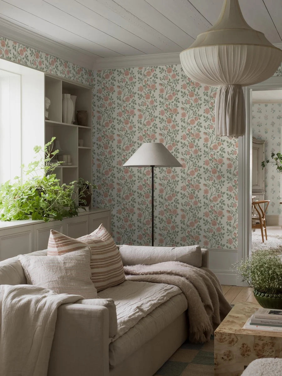  This gorgeous Elsa wallpaper features roses in softly colored, warm pink tones climbing upwards among green leaves and set against a cream background. 