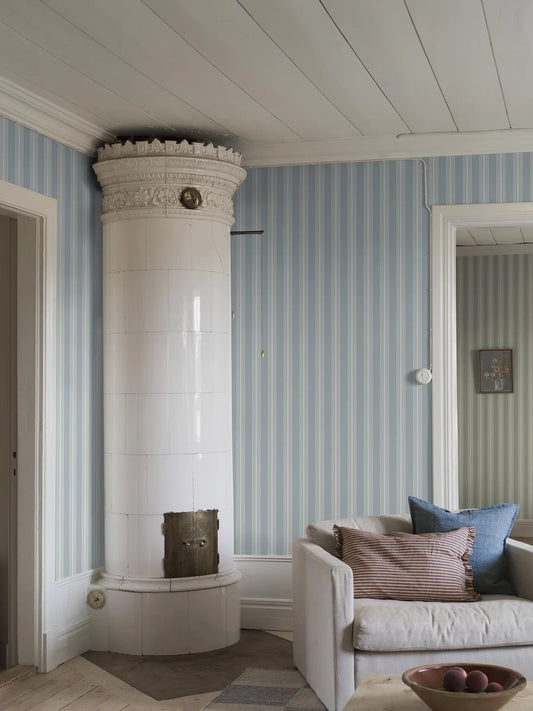  With its cream-colored stripes against a pastel blue background, this Gunnebo wallpaper is inspired by the neoclassical elegance of Gunnebo stately home in Sweden. 