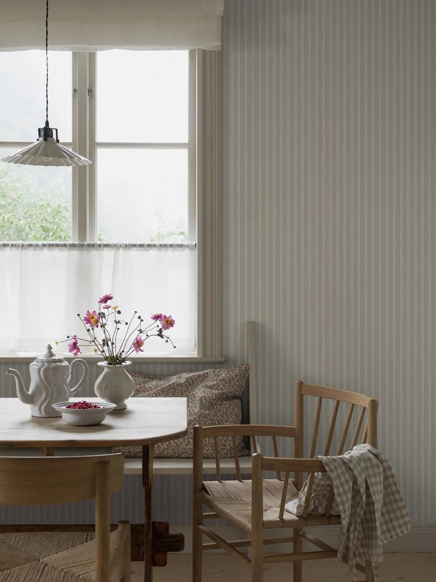 This classic striped Pärlband wallpaper has a harmonious mix of different beige tones on a cream background, accented with decorative brown dots.