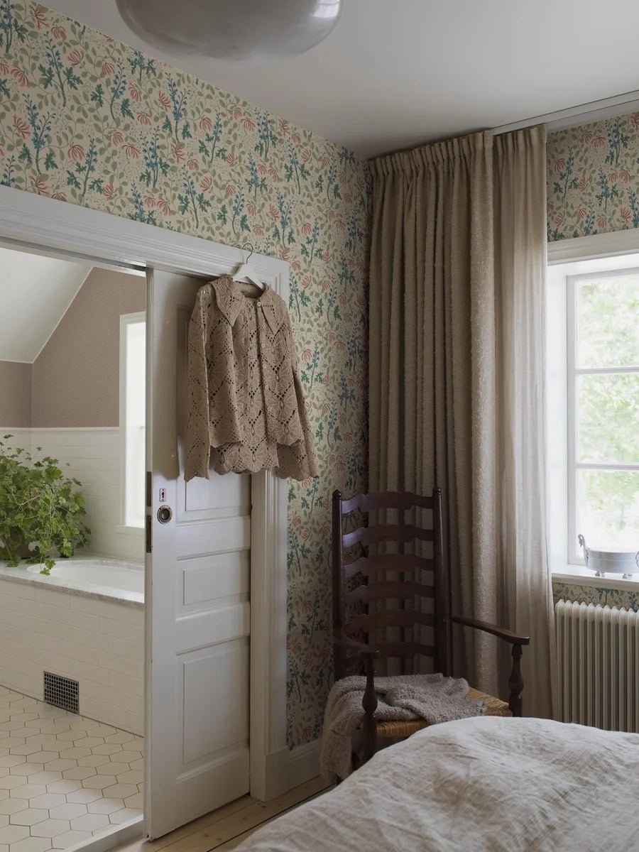 Trädgårdsfröjd wallpaper has a rich and multicolored floral pattern on a beige background.