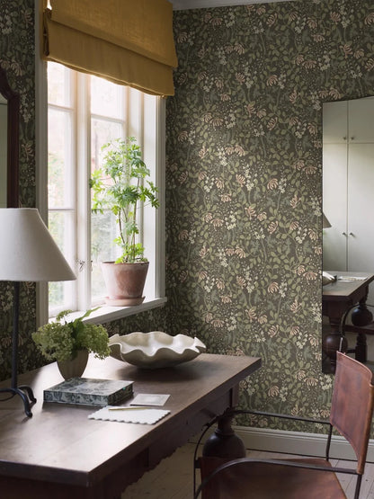 Trädgårdsfröjd wallpaper in dark green brings an enchanting, naturalistic touch to the room.