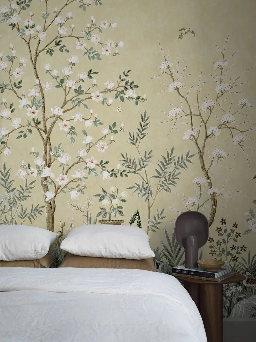 The pale yellow wallpaper Magnolia Garden is adorned with a lush, hand-painted pattern with Asian influences.