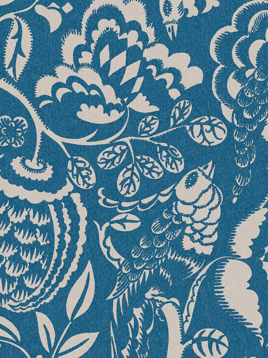 Wundervogel wallpaper in blue showcases whimsical birds and lush, winding plants in a large-scale pattern with modernist expressions evident in the pattern’s geometric and winding embellishments. 