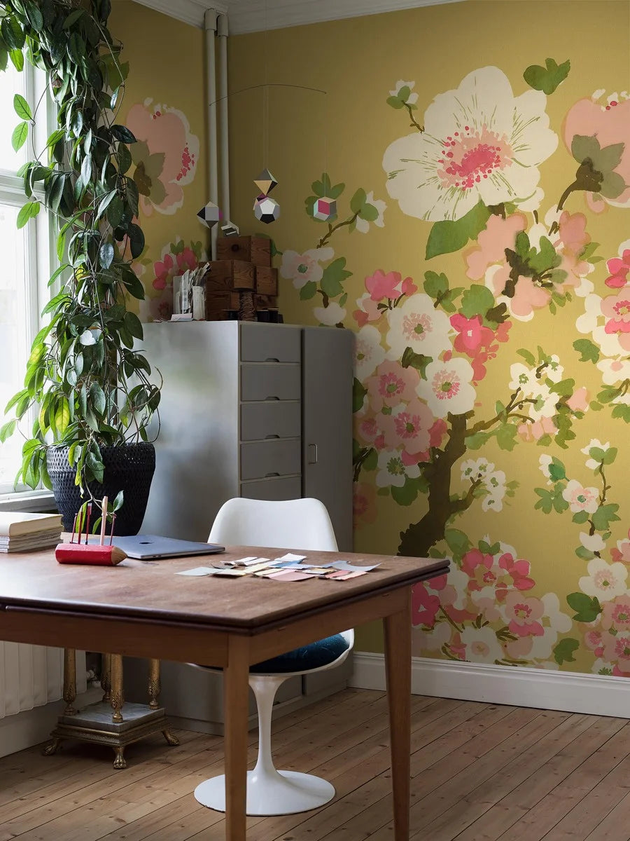 The Apple Blossom wallpaper is adorned with delicate apple blossoms, painted layer upon layer in watercolor.