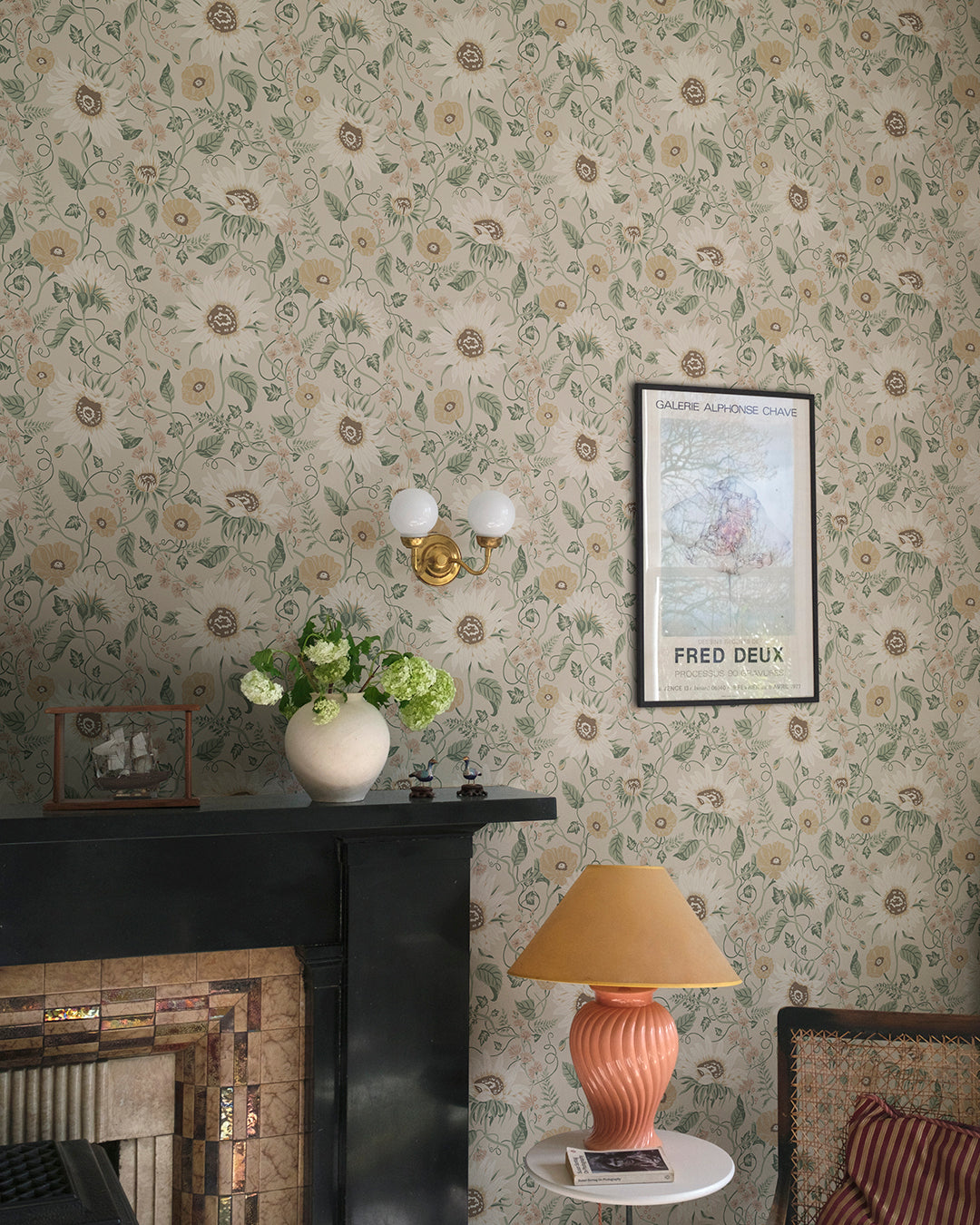 Wallpaper Solveig, Clay, has a warm beige base adorned by flowers in muted shades of warm yellow, beige, and pink with green foliage.